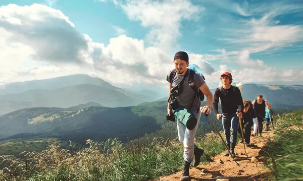 Companhia de amigos viajantes caminhando na colina da montanha com campo de grama, caminhadas em montanhas . — Fotografia de Stock