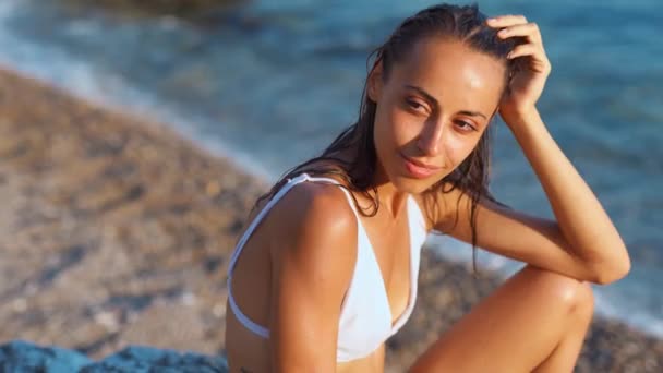 Mixed race woman with suntanned skin sitting pebble tropical beach — Stock Video