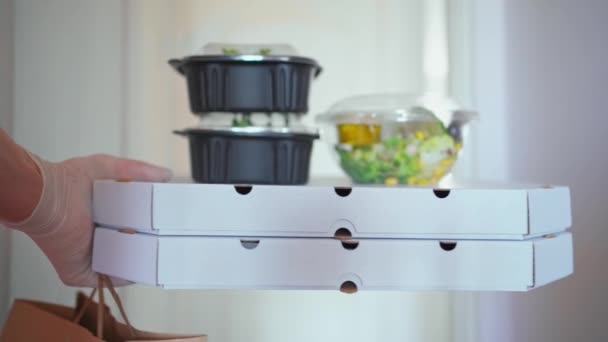 POV consegna uomo viene in appartamento e dà ordine al cliente, pizza in scatole e contenitori di plastica con insalate . — Video Stock