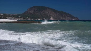 Çakıl taşlı deniz sahilinde ağır çekim dalgaları.