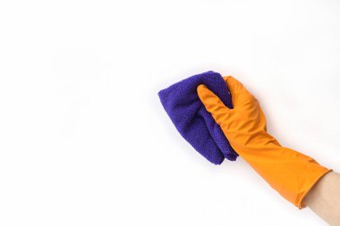  Koruyucu turuncu eldiven, izole edilmiş beyaz arka planda mor mikrofiber bez tutar. Metin veya logo için boş alan. Temizlik kavramı.