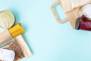 Mavi arka planda bağışçı yiyecekleri ve fotokopi alanı. Düz yatıyordu. Üst Manzara, Mock up. Pirinç, konserve yiyecek, karabuğday, reçel, makarna. Yiyecek bağışları ya da yemek servisi konsepti. Covid 19 karantinası sırasında online alışveriş