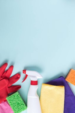 Düz kompozisyon. Mutfak, banyo ve diğer odalardaki farklı yüzey için deterjan ve temizlik aksesuarları. Mavi arkaplanda mesaj ya da logo için boş yer. Temizlik hizmeti konsepti. Üst Manzara. Dikey