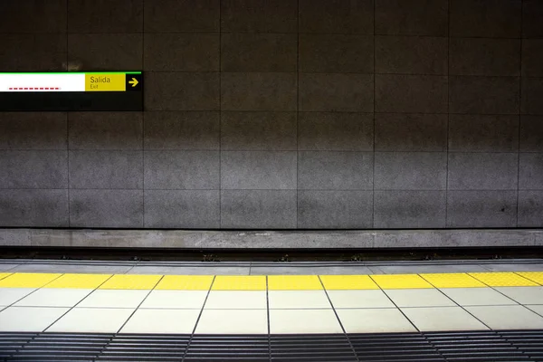 Modern subway station with yellow safety line signage