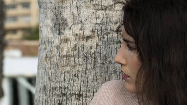 Genç bir kadın kumsalda dinleniyor güneşli bir günün tadını çıkarıyor.