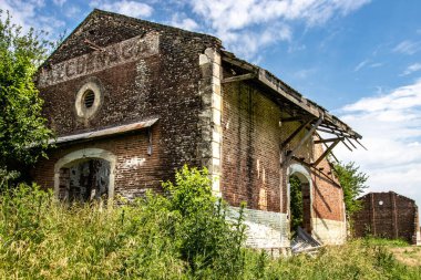 Yeşil bir alanda eski ve terk edilmiş bir tren istasyonu.