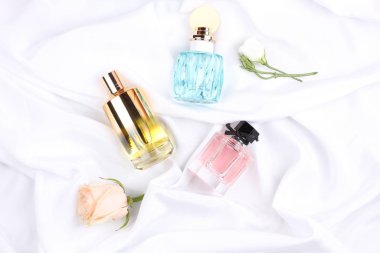 set of aroma perfumes with rose flowers on white background