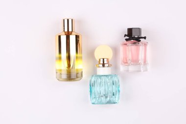 Beyaz arka planda tasarlanmış lüks parfüm şişeleri.