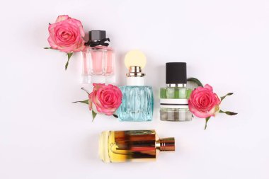 set of aroma perfumes with rose flowers on white background