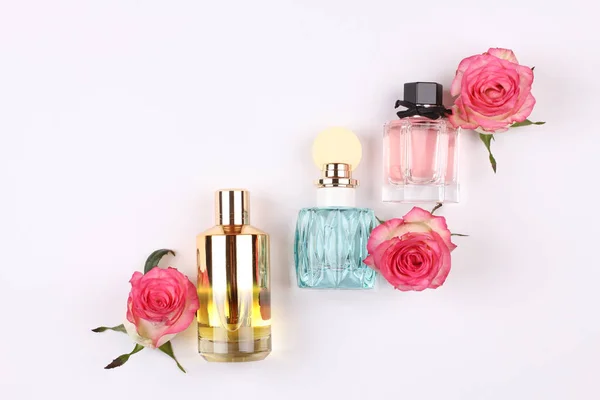 set of aroma perfumes with rose flowers on white background