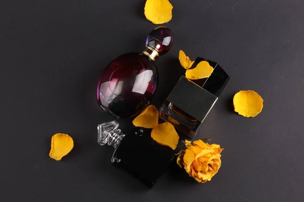 set of aroma perfumes with rose flowers on dark background