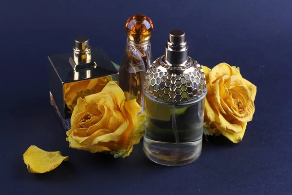 set of aroma perfumes with rose flowers on dark background