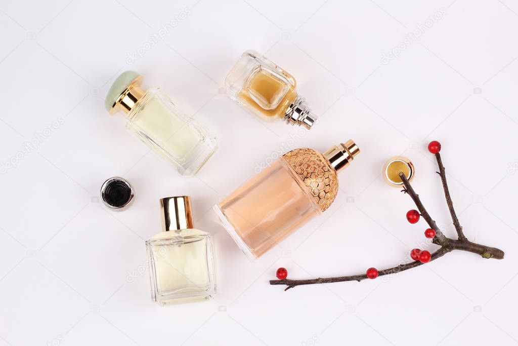 perfume bottles surrounded by flowers on white background 