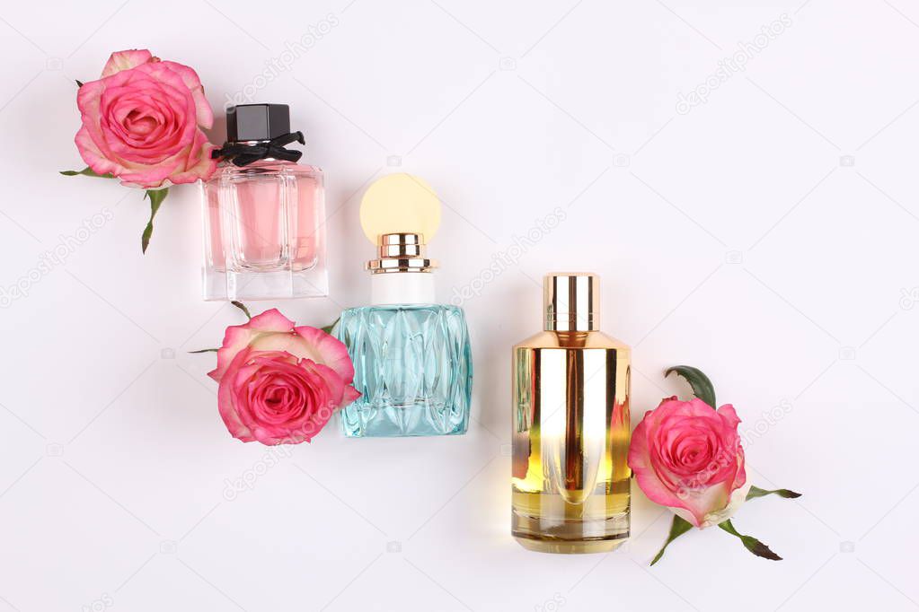 set of aroma perfumes with rose flowers on white background