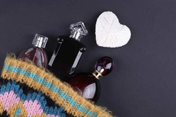 set of perfumes with clothes on black background