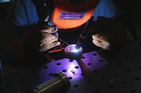 Een industriële tig lasser werkt in een werkplaats Stockfoto