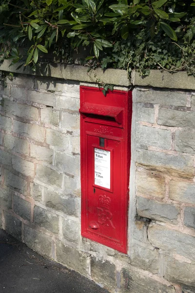Red postal box in brick wall