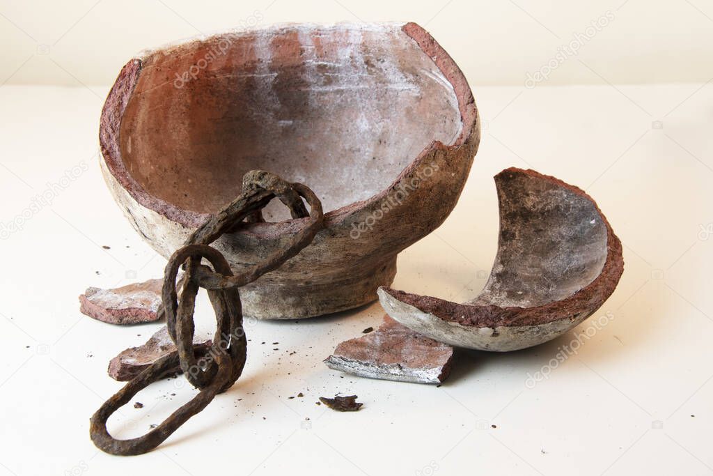 Old rustic chain inside broken clay pot