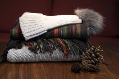 Forma, şapka ve fular, turuncu ve gri, arka planda kanepe.