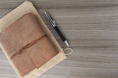 Tahtaya kalem yapıştırılmış deri kaplı kitabın en üst görüntüsü