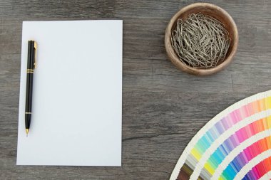 Tahta üzerinde boş beyaz sayfa ve renk aralığı kartlarının üst görünümü