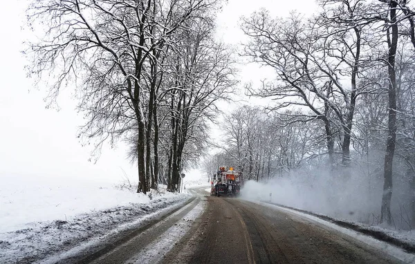 Nieve arenisca espolvorear sal en el camino Fotos de stock libres de derechos