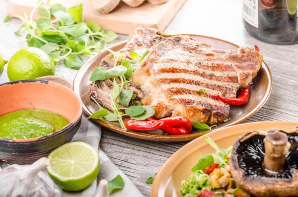 Chuletas de cerdo a la parrilla, risotto con portobello — Foto de Stock