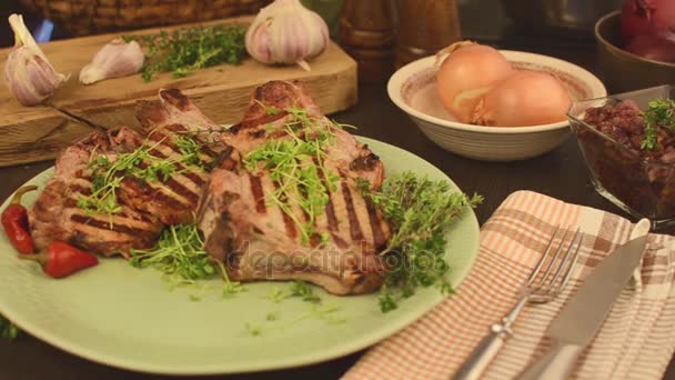 Chuletas de cerdo a la parrilla con cebolla caramelizada, sirviendo — Vídeos de Stock