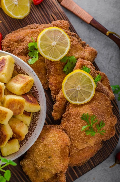 Schnitzel original with lemon and gnocchi fried — Stock Photo, Image