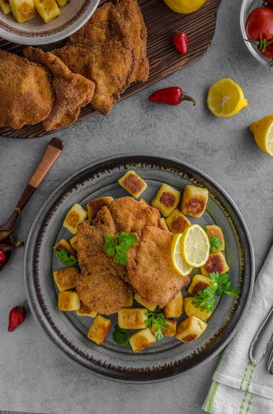 Schnitzel original with lemon and gnocchi fried — Stock Photo, Image