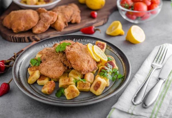 Schnitzel original with lemon and gnocchi fried — Stock Photo, Image