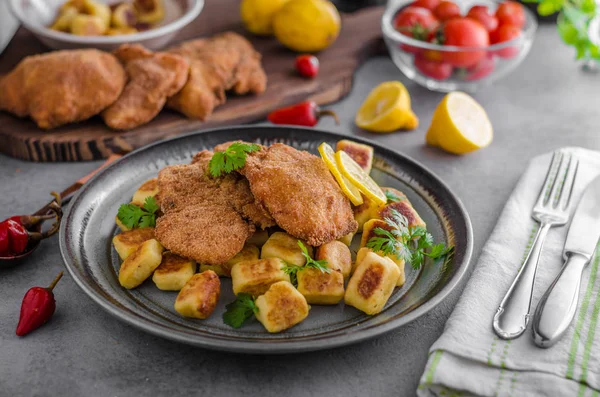 Schnitzel original with lemon and gnocchi fried — Stock Photo, Image