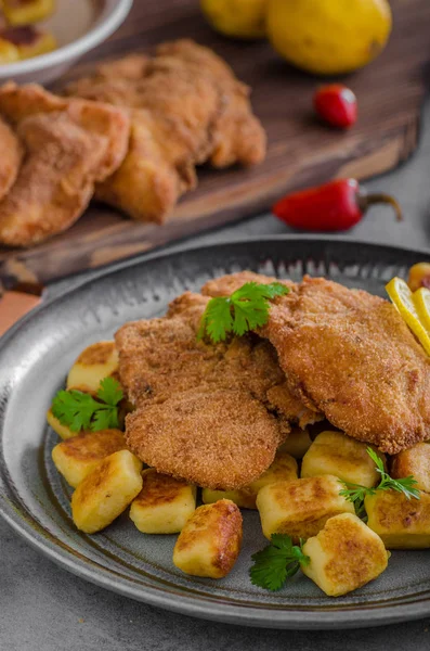 Schnitzel original with lemon and gnocchi fried — Stock Photo, Image