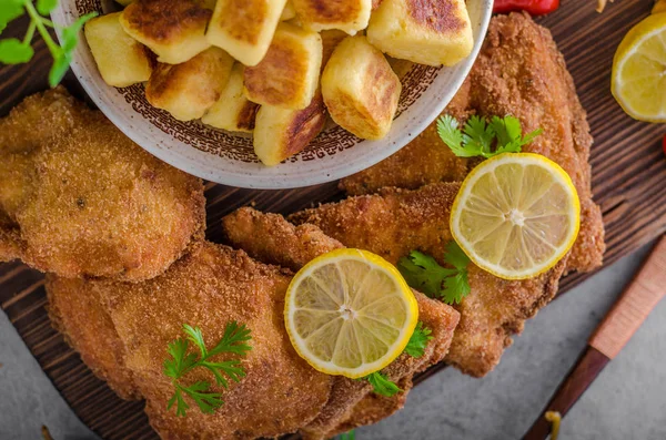 Schnitzel original with lemon and gnocchi fried — Stock Photo, Image