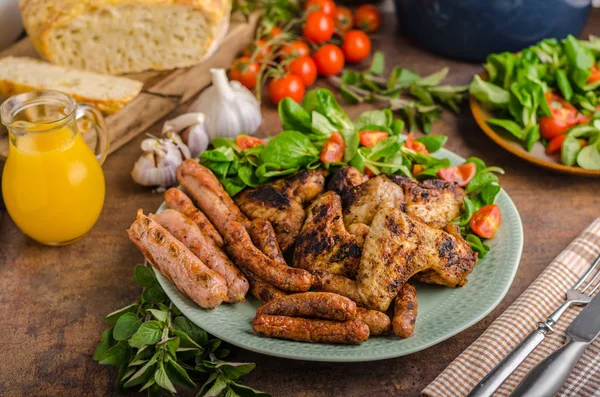 Grilled chicken wings and sausages — Stock Photo, Image