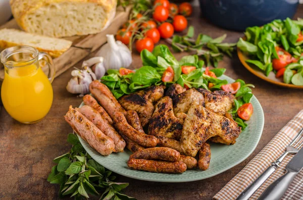 Alitas y salchichas de pollo a la parrilla — Foto de Stock