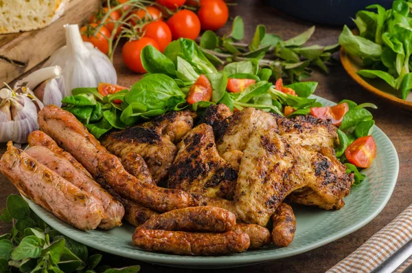 Alitas y salchichas de pollo a la parrilla — Foto de Stock