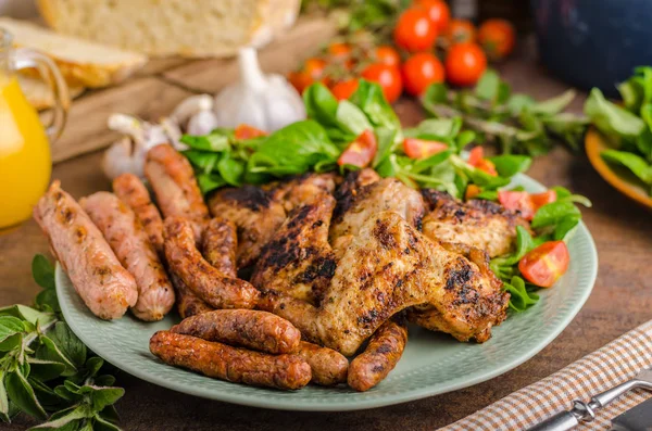 Alitas y salchichas de pollo a la parrilla — Foto de Stock