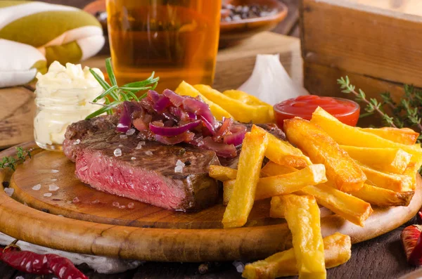 Bife com batatas fritas caseiras, cerveja e molho tártaro — Fotografia de Stock