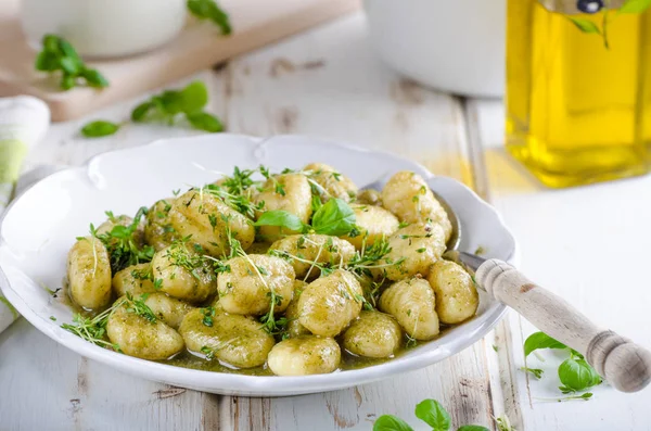 Pesto gnocchi, garlic and fresh herbs olive oil — Stock Photo, Image