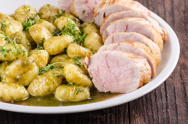 Pork tenderloin with herbs and spices, pesto gnocchi — Stock Photo, Image