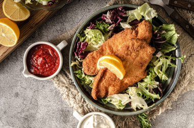 Salata ve mayonez soslu gevrek ve ölü şnitzel.