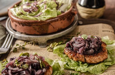 Karamelli kırmızı soğanlı lezzetli biftek ve salatada taze otlar.
