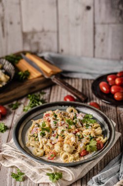 Bitki ve peynir soslu İtalyan tortellini