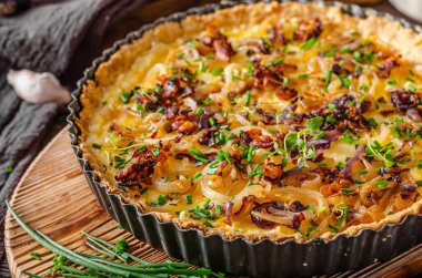 Kızarmış soğan ve kızarmış domuz pastırmalı lezzetli rustik kiş.