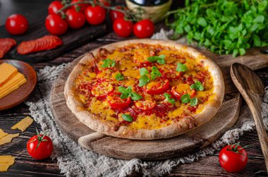 Keskin çedar peynirli ve baharatlı salamlı ev yapımı pizza.