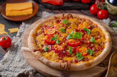 Keskin çedar peynirli ve baharatlı salamlı ev yapımı pizza.