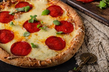 Lezzetli ve sade ev yapımı salamlı ve peynirli pizza.