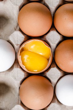 Tabakta kırık yumurta ve diğer yumurtalar.