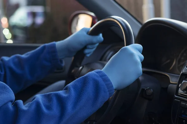 The man behind the wheel in rubber gloves
